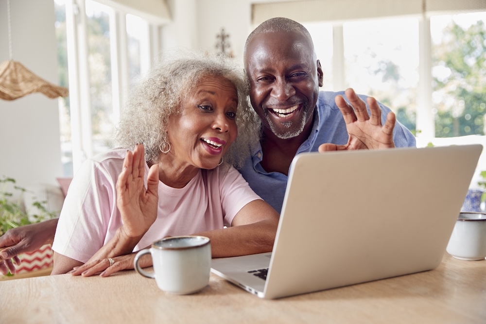 An older couple enjoy simplified senior communication on their laptop.