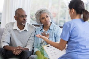 Caregiver talking to a senior couple.