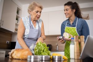 A woman receiving caregiver support for diabetes prepares a meal with her caregiver.