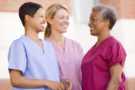 Three diverse nurses in scrubs smiling