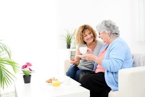 Woman talking on the couch with senior loved one