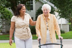 caregiver-with-senior-using-walker-outside_B