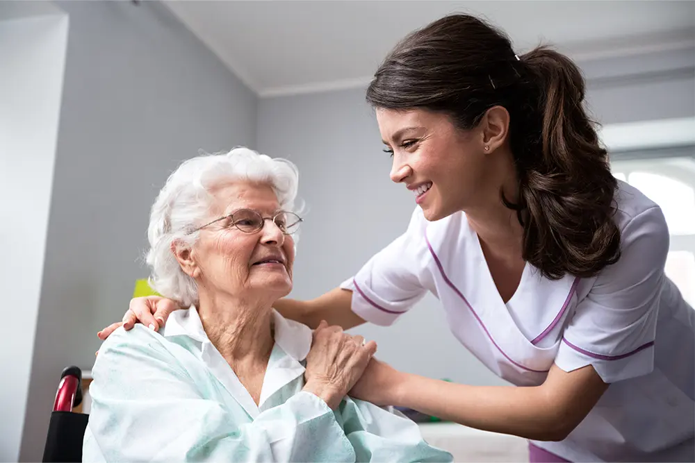 A caregiver provides palliative care in Burlington for an older woman at home.