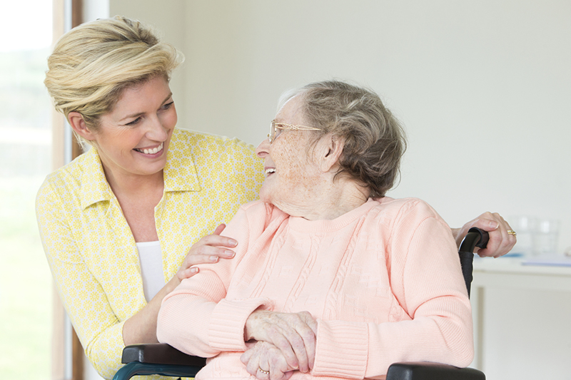 smiling-caregiver-with-disabled-senior-woman-wheelchair